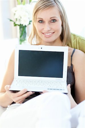 simsearch:400-04709946,k - Glowing woman showing a laptop sitting on a sofa at home Stockbilder - Microstock & Abonnement, Bildnummer: 400-04700445