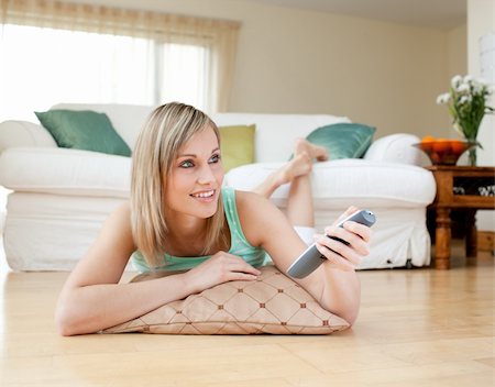 simsearch:400-04212407,k - Beautiful blond woman watching TV lying on the floor at home Stock Photo - Budget Royalty-Free & Subscription, Code: 400-04700467