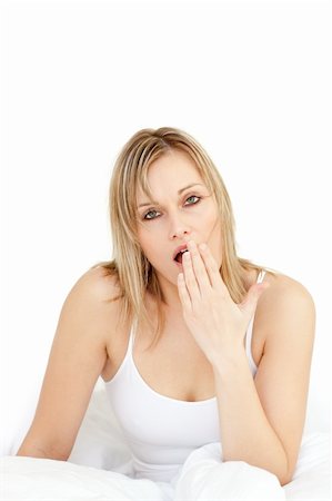 simsearch:400-05729350,k - Charming woman yawning on her bed against a white background Photographie de stock - Aubaine LD & Abonnement, Code: 400-04700539