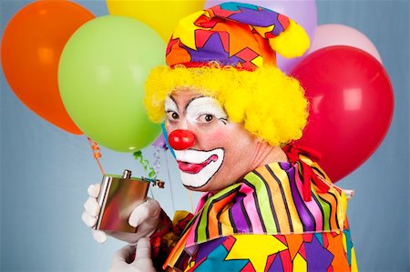 drunk man dressed up - Alcoholic clown sneaks a drink from his flask. Stock Photo - Budget Royalty-Free & Subscription, Code: 400-04700596