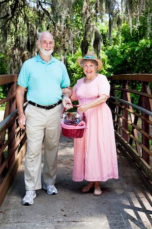 Senior couple carrying a picnic basket through the park. Photographie de stock - Aubaine LD & Abonnement, Code: 400-04702186