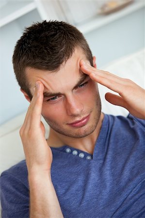 Depressed man having a headache in the living room Stock Photo - Budget Royalty-Free & Subscription, Code: 400-04702329