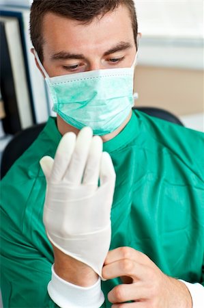 Portrait of a surgeon in scrubs uniform looking at his hand Stock Photo - Budget Royalty-Free & Subscription, Code: 400-04702336