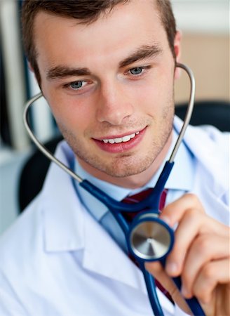 Charming young doctor examining with a stethoscope  in his office Stock Photo - Budget Royalty-Free & Subscription, Code: 400-04702331