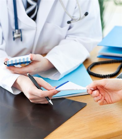 patient talking to office worker - A doctor giving his patient a prescription in his office Stock Photo - Budget Royalty-Free & Subscription, Code: 400-04702356