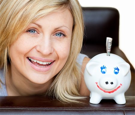 pig profile - Laughing woman with a piggy bank on a sofa looking at the camera Stock Photo - Budget Royalty-Free & Subscription, Code: 400-04702390