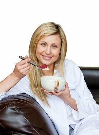 simsearch:400-04708507,k - Charming woman eating cereals on the sofa against white background Stock Photo - Budget Royalty-Free & Subscription, Code: 400-04702391