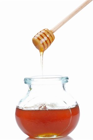 simsearch:400-04865454,k - Pouring honey on glass jar isolated on white background. Shallow depth of field Stockbilder - Microstock & Abonnement, Bildnummer: 400-04702475