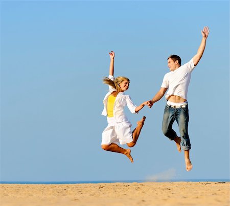 simsearch:400-04702706,k - Playful couple jumping and smiling on the beach Stockbilder - Microstock & Abonnement, Bildnummer: 400-04702692