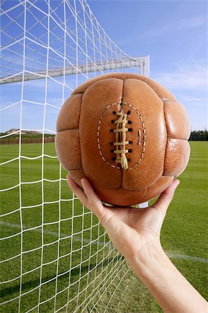simsearch:400-04397543,k - Football vintage ball in hand net soccer goal green grass background Fotografie stock - Microstock e Abbonamento, Codice: 400-04703936
