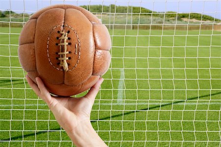 simsearch:400-04397543,k - Football vintage ball in hand net soccer goal green grass background Fotografie stock - Microstock e Abbonamento, Codice: 400-04703937