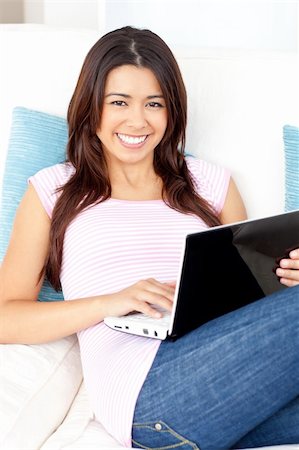 simsearch:400-04709946,k - Bright asian woman using her laptop at home smiling at the camera Stockbilder - Microstock & Abonnement, Bildnummer: 400-04714590