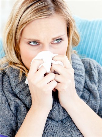 simsearch:400-04212905,k - Dejected woman lying on a sofa with tissues and blowing against a white background Stock Photo - Budget Royalty-Free & Subscription, Code: 400-04715318