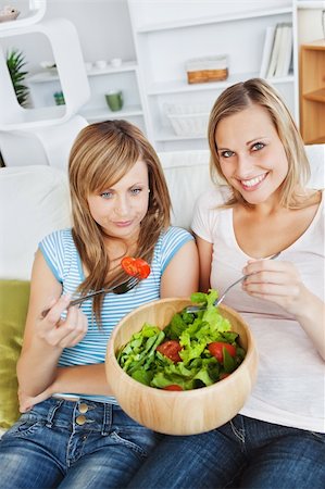 simsearch:400-04212407,k - Hungry women eating a salad in the living-room at home Stock Photo - Budget Royalty-Free & Subscription, Code: 400-04715522