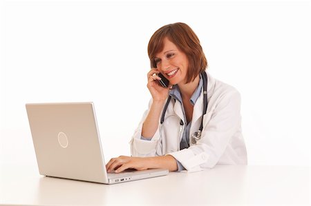 simsearch:400-04704005,k - Portrait of young woman doctor in white coat at computer using phone Stock Photo - Budget Royalty-Free & Subscription, Code: 400-04715566