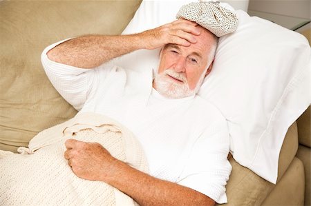 Senior man home sick in bed, with an ice pack on his head.  Could be hangover or illness. Stock Photo - Budget Royalty-Free & Subscription, Code: 400-04715597