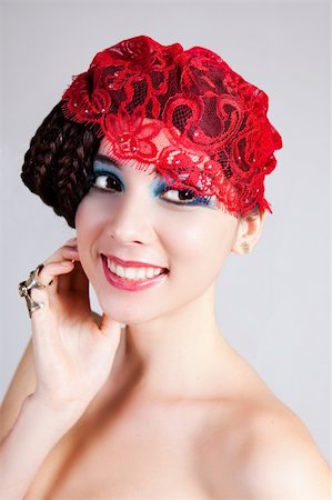 simsearch:693-03707560,k - A glamorous, high fashion woman smiles to the side while posing with red lace headpiece on her head and bare shoulders. Vertical shot. Fotografie stock - Microstock e Abbonamento, Codice: 400-04716474