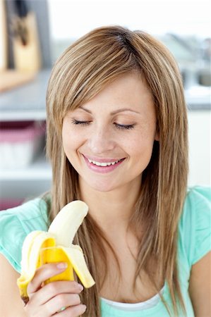 pretty women eating banana - Smiling young woman holding a banana in the kitchen at home Stock Photo - Budget Royalty-Free & Subscription, Code: 400-04716517