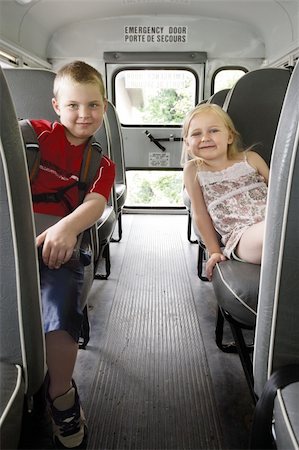 sitting at bus stop - Photo of two happy children sitting in a school bus. Stock Photo - Budget Royalty-Free & Subscription, Code: 400-04716642