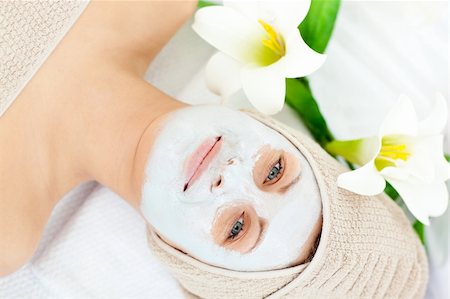 simsearch:400-04127590,k - Glowing woman lying on a massage table with white cream on her face looking at the camera in a spa center Stock Photo - Budget Royalty-Free & Subscription, Code: 400-04717236