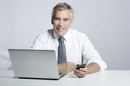 simsearch:400-04204942,k - happy senior smiling businessman laptop computer mobile phone portrait Stock Photo - Budget Royalty-Free & Subscription, Code: 400-04717258