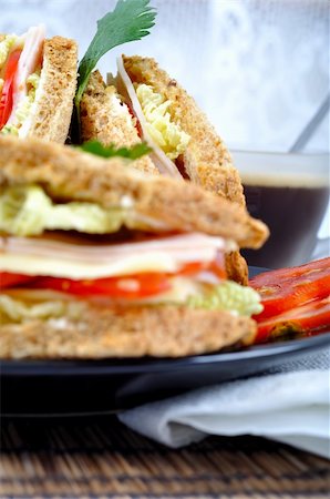 fresh and delicious classic club sandwich over a black glass dish with coffee and vegetable Stock Photo - Budget Royalty-Free & Subscription, Code: 400-04717994