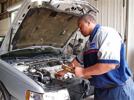 Auto mechanic checking radiator levels while performing a routine service inspection in a service garage. Photographie de stock - Aubaine LD & Abonnement, Code: 400-04718109
