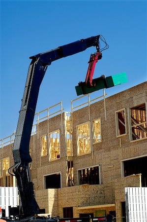 simsearch:400-05249204,k - construction work in progress crane lifting wood planks to the roof top Stock Photo - Budget Royalty-Free & Subscription, Code: 400-04718432