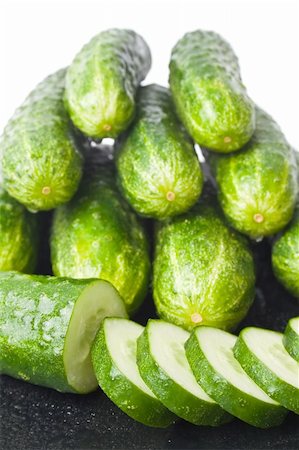 simsearch:400-05705062,k - cucumbers and a cucumber cut in circles, washed and placed in a black ceramic plate isolated on white background Photographie de stock - Aubaine LD & Abonnement, Code: 400-04712142