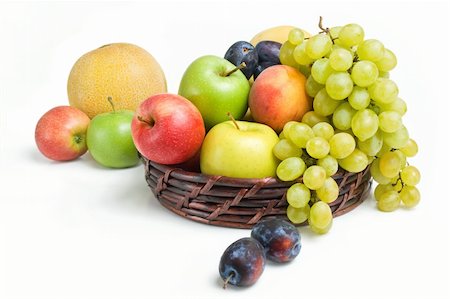 simsearch:400-05194830,k - Various fresh ripe fruits placed in a wicker basket and around isolated on a white background Stockbilder - Microstock & Abonnement, Bildnummer: 400-04712548