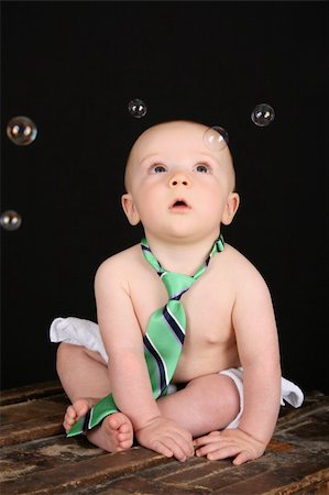 simsearch:400-05727835,k - Cute baby boy sitting on an antique trunk looking at bubbles Fotografie stock - Microstock e Abbonamento, Codice: 400-04712822