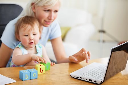 Positive family using laptop and playing with toys in the living-room Stock Photo - Budget Royalty-Free & Subscription, Code: 400-04712944