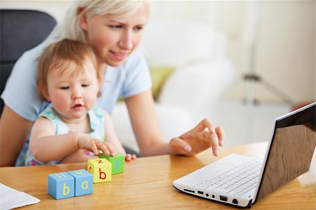 Positive family using laptop and playing with toys in the living-room Foto de stock - Super Valor sin royalties y Suscripción, Código: 400-04712944