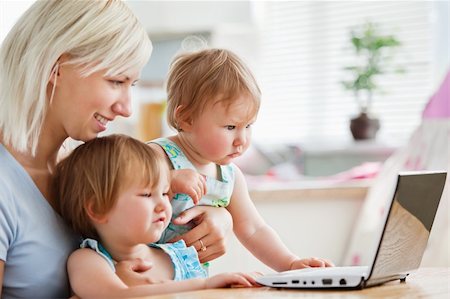 Astonished children looking at a laptop with their mother at home Stock Photo - Budget Royalty-Free & Subscription, Code: 400-04712945