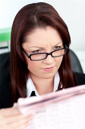 simsearch:632-01157433,k - Glowing young businesswoman reading a newspaper in her office with glasses Stock Photo - Budget Royalty-Free & Subscription, Code: 400-04712955