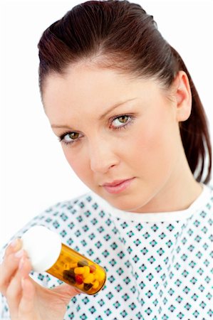 simsearch:400-05892402,k - Depressed sick woman holding pills looking at the camera against white background Stock Photo - Budget Royalty-Free & Subscription, Code: 400-04712959