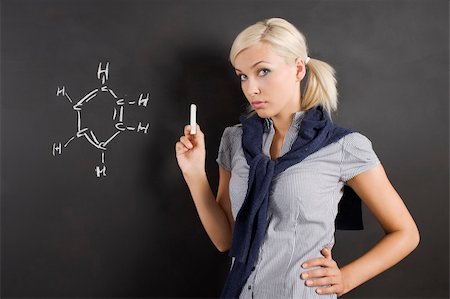 simsearch:400-05755412,k - pretty young college student near a blackboard with a white chalk in hand looking in camera Photographie de stock - Aubaine LD & Abonnement, Code: 400-04712993