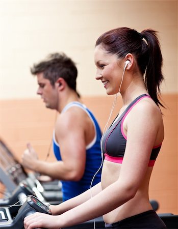 simsearch:400-04256139,k - Young athletes exercising on a running machine with earphones in a fitness center Stock Photo - Budget Royalty-Free & Subscription, Code: 400-04724127