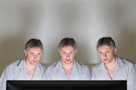 Three identical clones or triplets watching television or a computer screen together Stock Photo - Budget Royalty-Free & Subscription, Code: 400-04725194