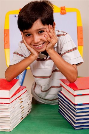 simsearch:400-08429355,k - Young boy leaned over pile of books Photographie de stock - Aubaine LD & Abonnement, Code: 400-04725214
