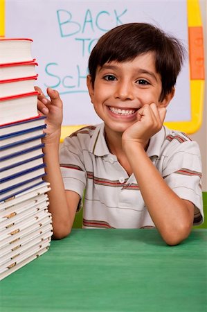 simsearch:400-08429355,k - Happy young school boy with stacked books Photographie de stock - Aubaine LD & Abonnement, Code: 400-04725215