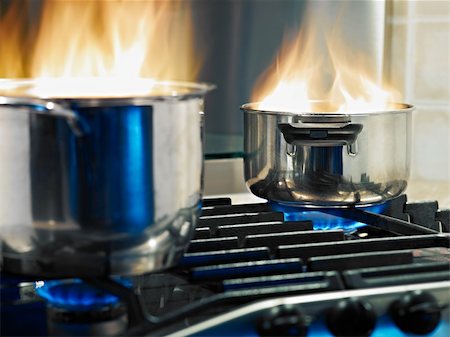 pan to the fire - pans in fire on stoves. Horizontal shape Foto de stock - Super Valor sin royalties y Suscripción, Código: 400-04727487