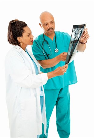 simsearch:400-05088220,k - Serious African American doctors reviewing a patient's medical x-rays. Isolated on white. Stock Photo - Budget Royalty-Free & Subscription, Code: 400-04728287