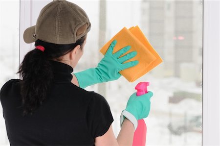 The woman in a cap and green gloves washes a window Fotografie stock - Microstock e Abbonamento, Codice: 400-04728797