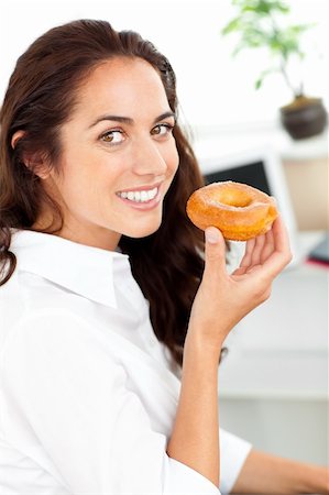 fat corporate woman - Smiling hispanic businesswoman eating a doughnut in her office Foto de stock - Super Valor sin royalties y Suscripción, Código: 400-04729479