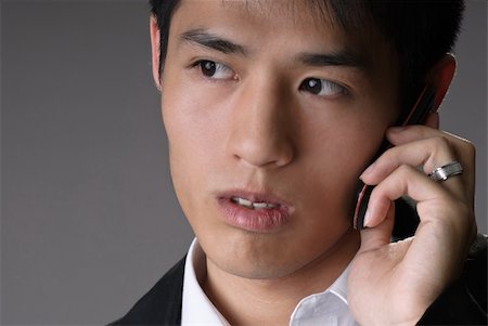 simsearch:400-04255437,k - Handsome young business man using cellphone, closeup portrait over studio gray background. Foto de stock - Super Valor sin royalties y Suscripción, Código: 400-04729548