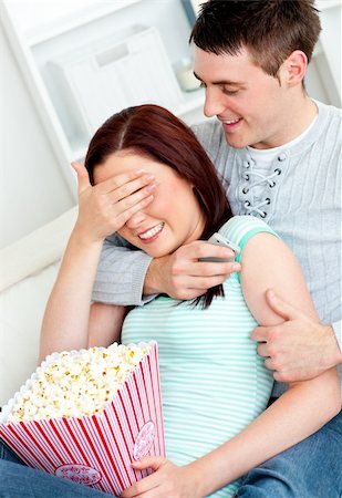 Charming couple lying on the sofa with popcorn and remote at home Stock Photo - Budget Royalty-Free & Subscription, Code: 400-04720006