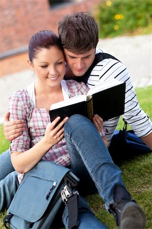 Serious couple of students reading a book sitting on grass at their campus university Stock Photo - Budget Royalty-Free & Subscription, Code: 400-04720155