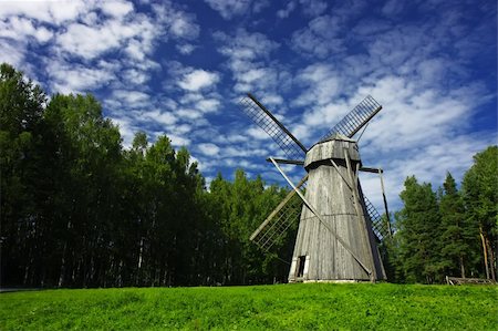 roxxer (artist) - Old rural windmill on a meadow, surrounded by forest. High-contrast cloudscape. Fotografie stock - Microstock e Abbonamento, Codice: 400-04720179