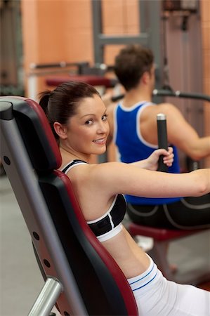 simsearch:400-05677914,k - Pretty athletic woman using a shoulder press in a fitness center Stock Photo - Budget Royalty-Free & Subscription, Code: 400-04720189